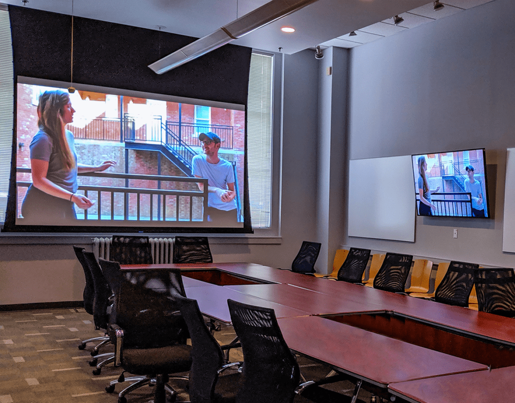 Mcc conference room av installation sgowing both digital signage and presentation solutions such as projection systems and ceiling mics and speakers.