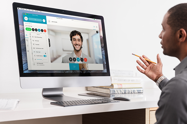 Businessman sitting at a computer having a webex video meeting