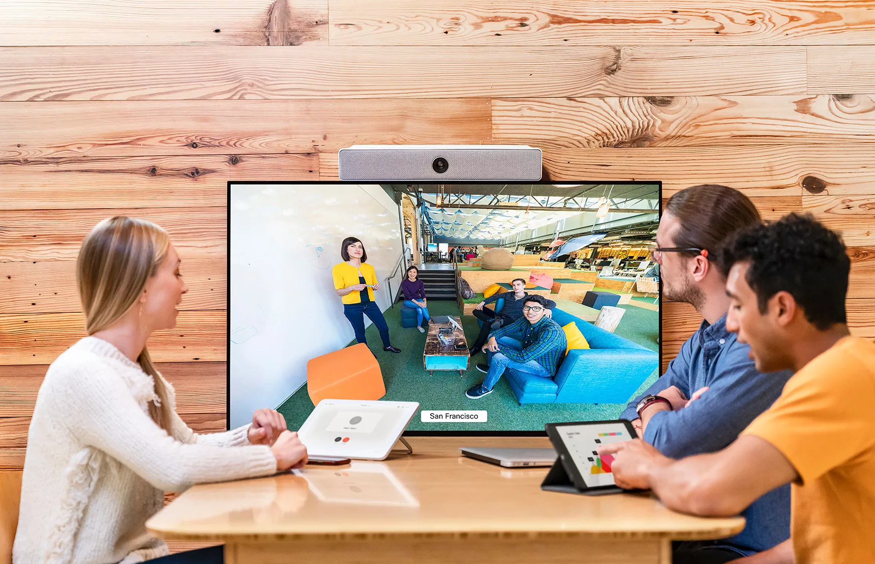 Cisco huddle space with three people sitting around watching a webex meeting. Mcc office technology solutions