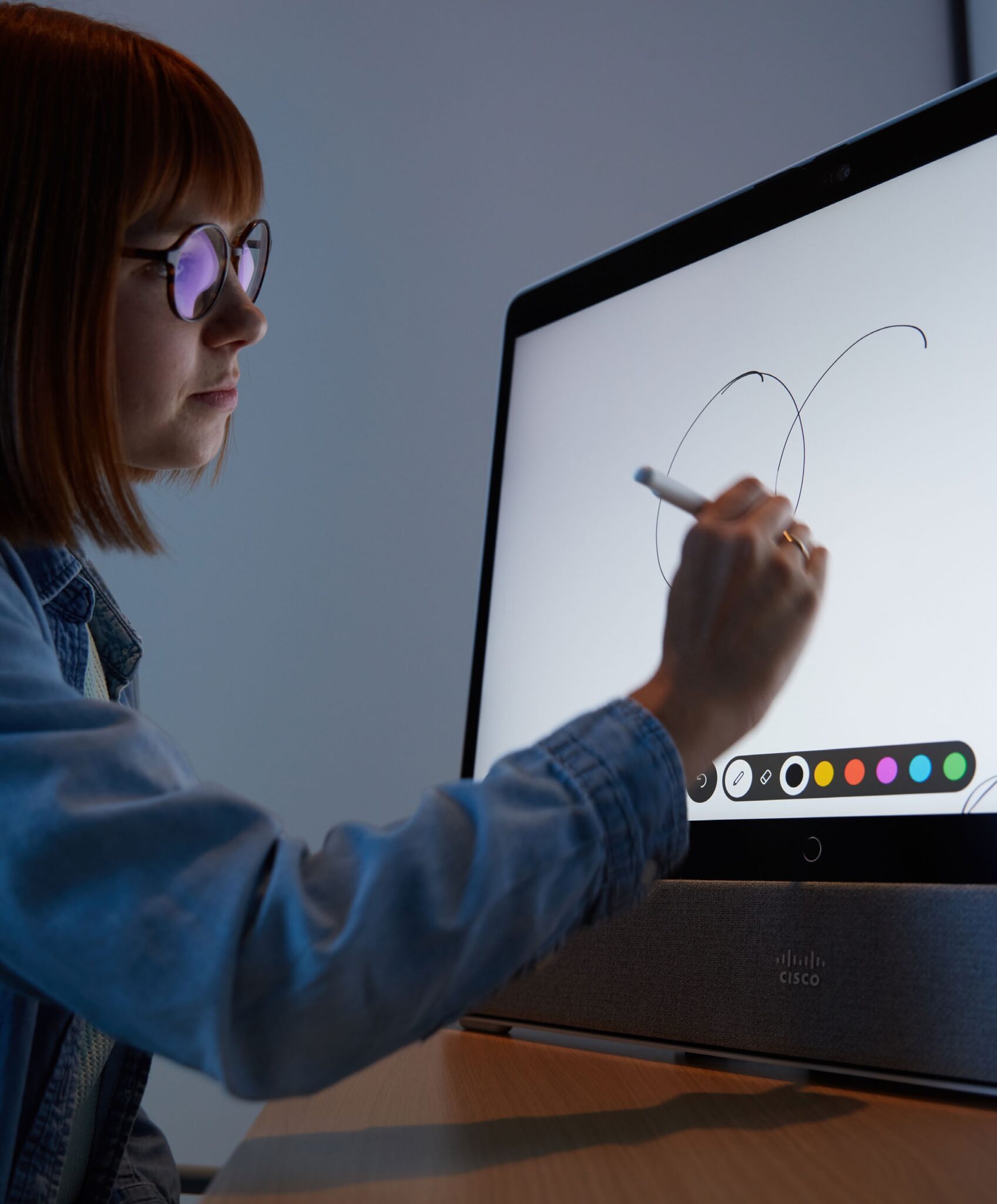 Woman using a cisco webex desk pro with a builtin digital whiteboard