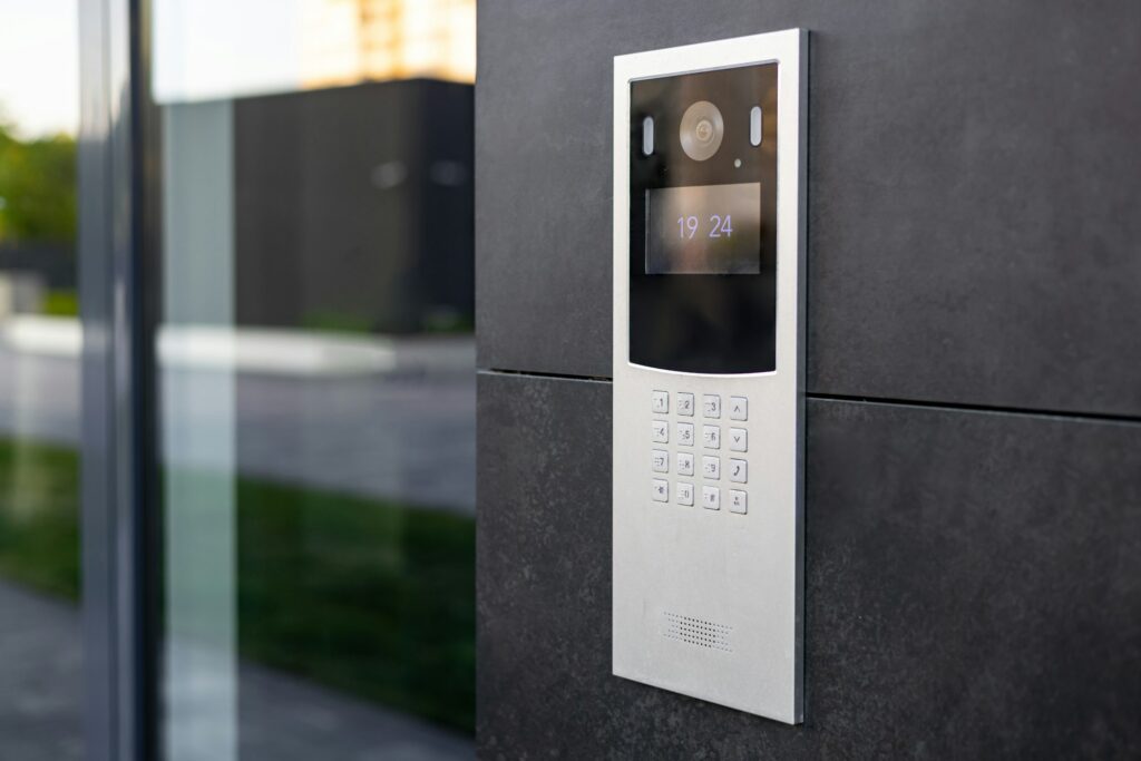 Entrance intercom systems in a multi-apartment building, with a video surveillance camera, on a dark wall