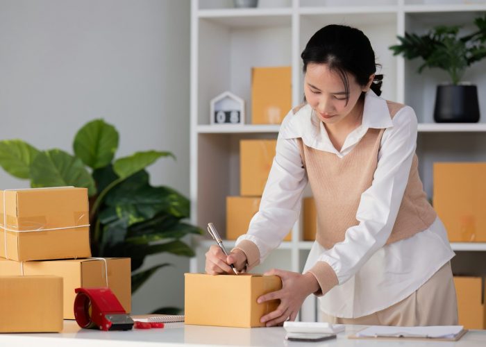 SME business entrepreneurs small in asia Writing shipping information on a cardboard box in my home